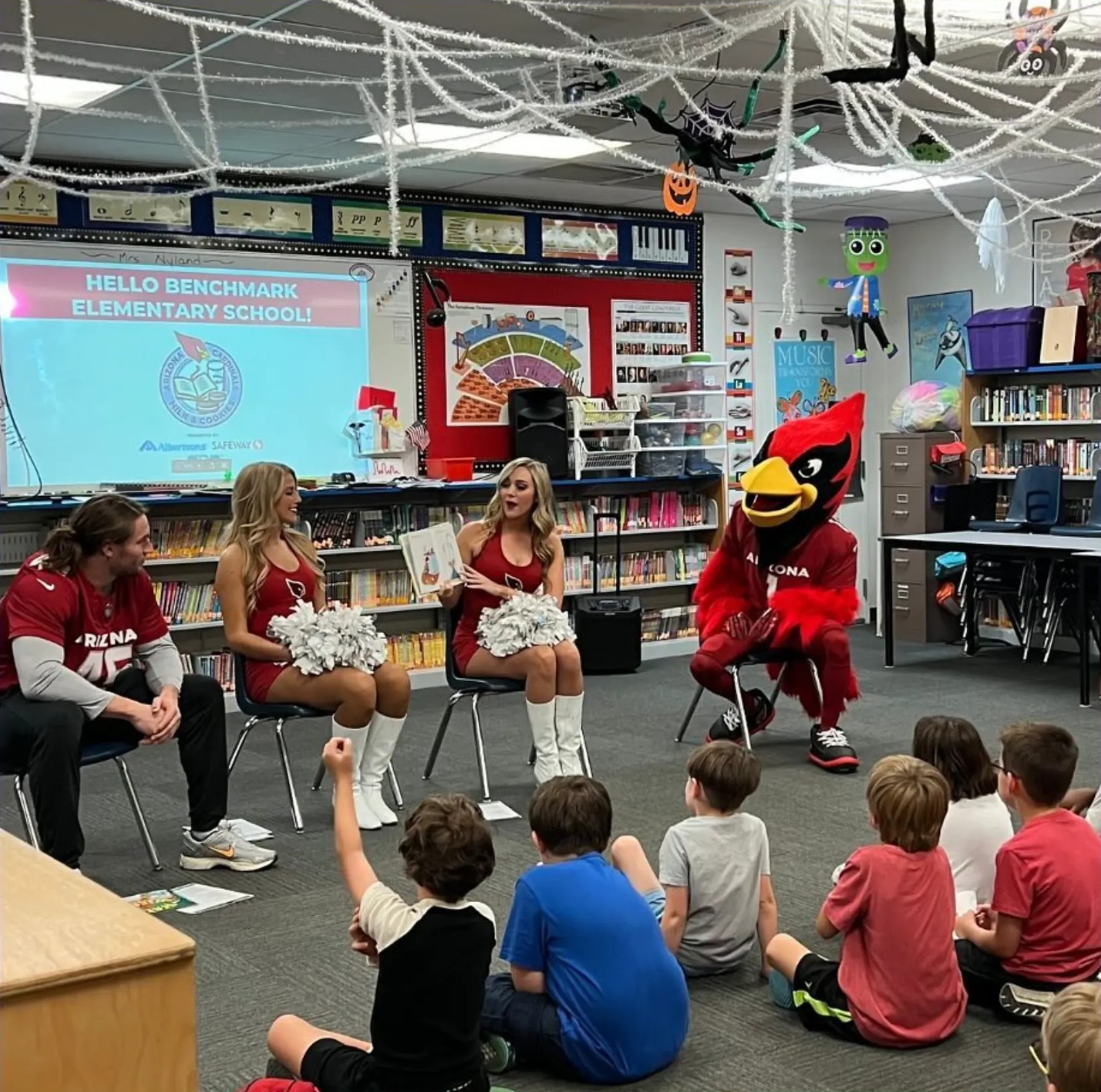 Benchmark students welcoming Arizona Cardinals guests and their mascot to the school